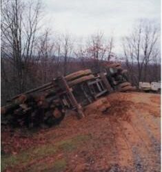 LOG TRUCK OVERTURNS ON SOFT WOODS ROAD